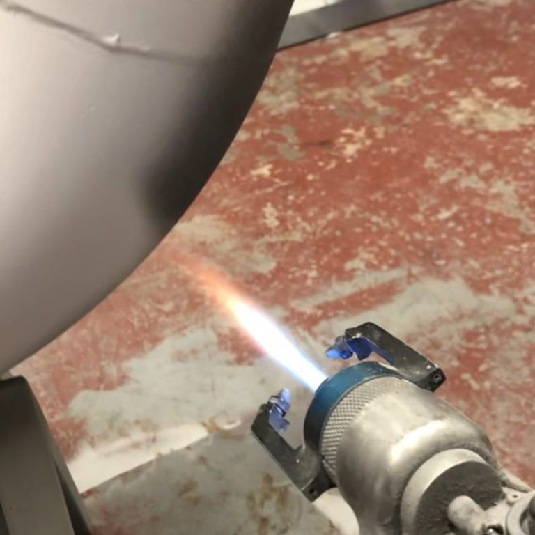 Thermal spray gun applying aluminium coating to marine silencer body for long term corrosion protection - Corrotec thermal spray Wirral